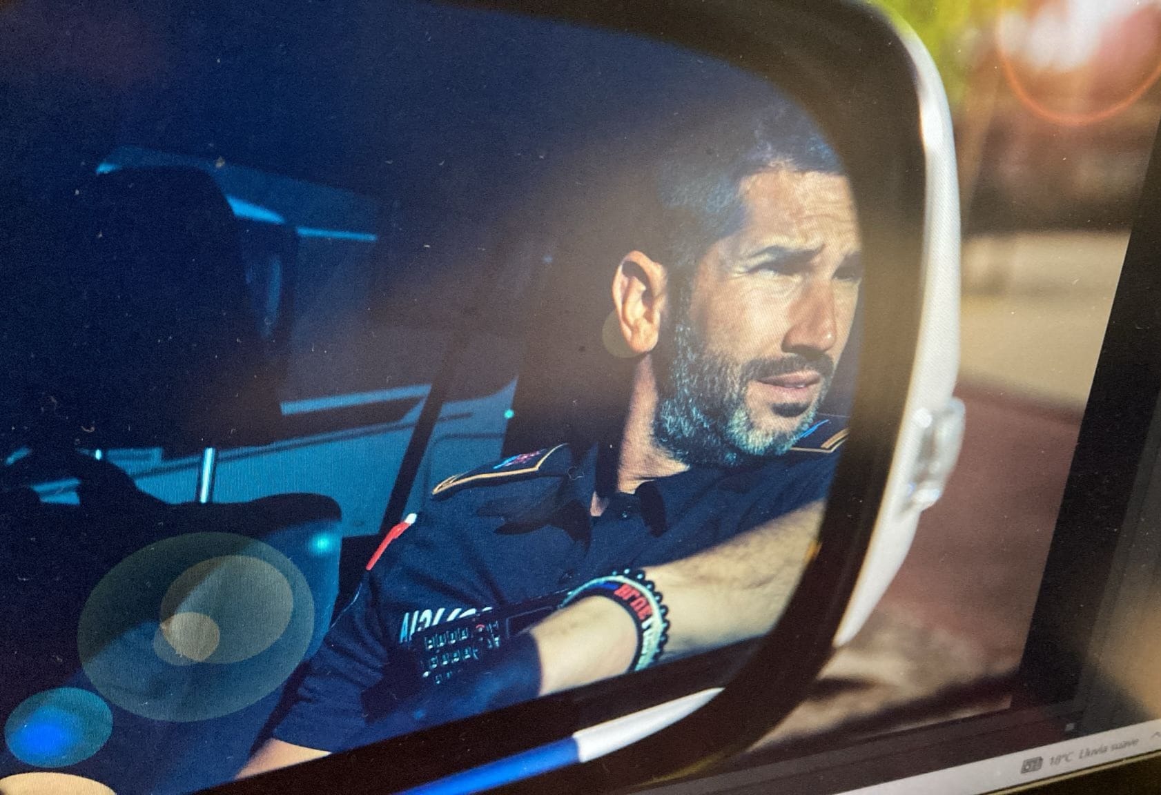 Javier Arroyo reflejado en el retrovisor de un vehículo policial durante el servicio